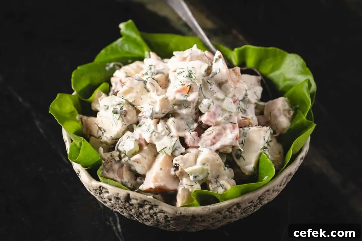 Lobster salad on a bed of leafy greens in a bowl.