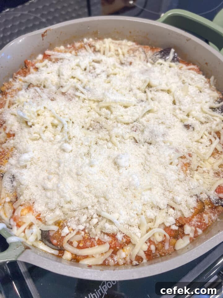 Eggplant parmesan skillet sprinkled with cheese and breadcrumbs, unbaked