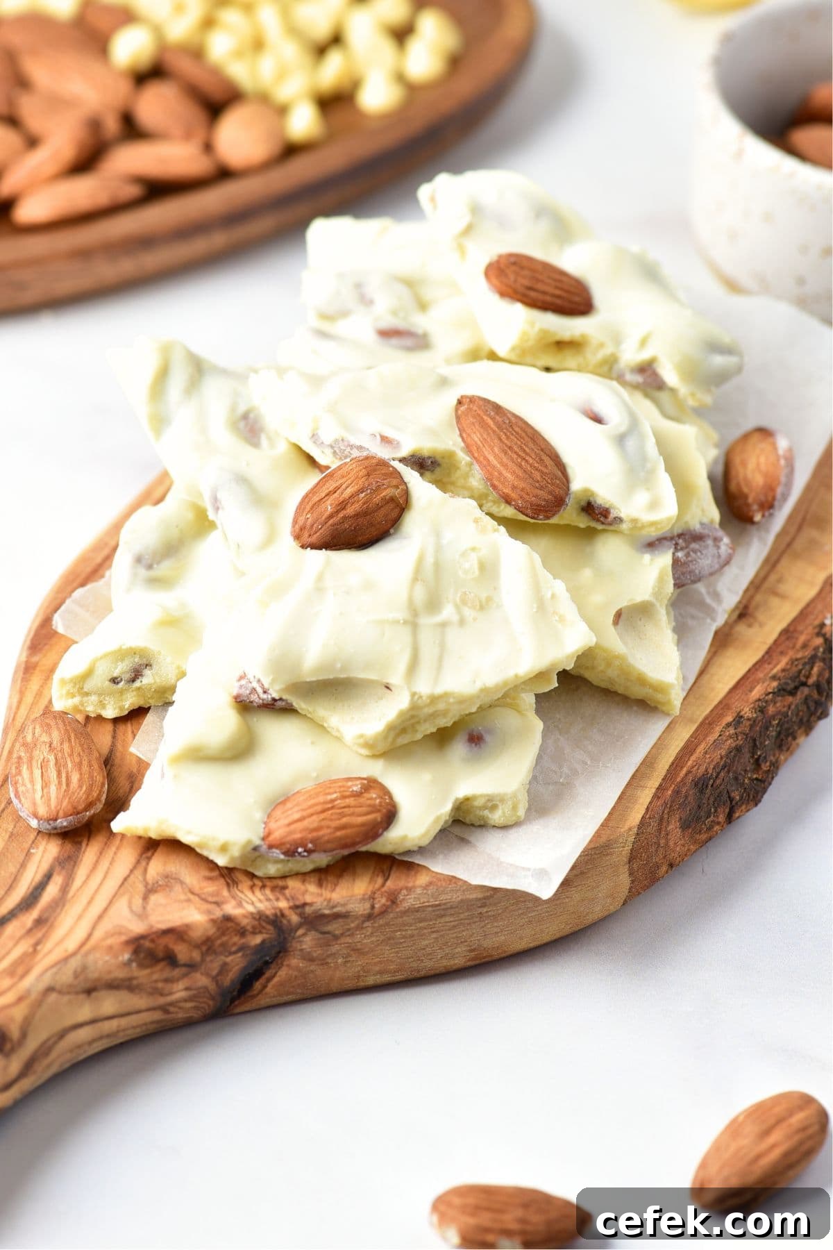 Pieces of white chocolate almond bark on wooden board