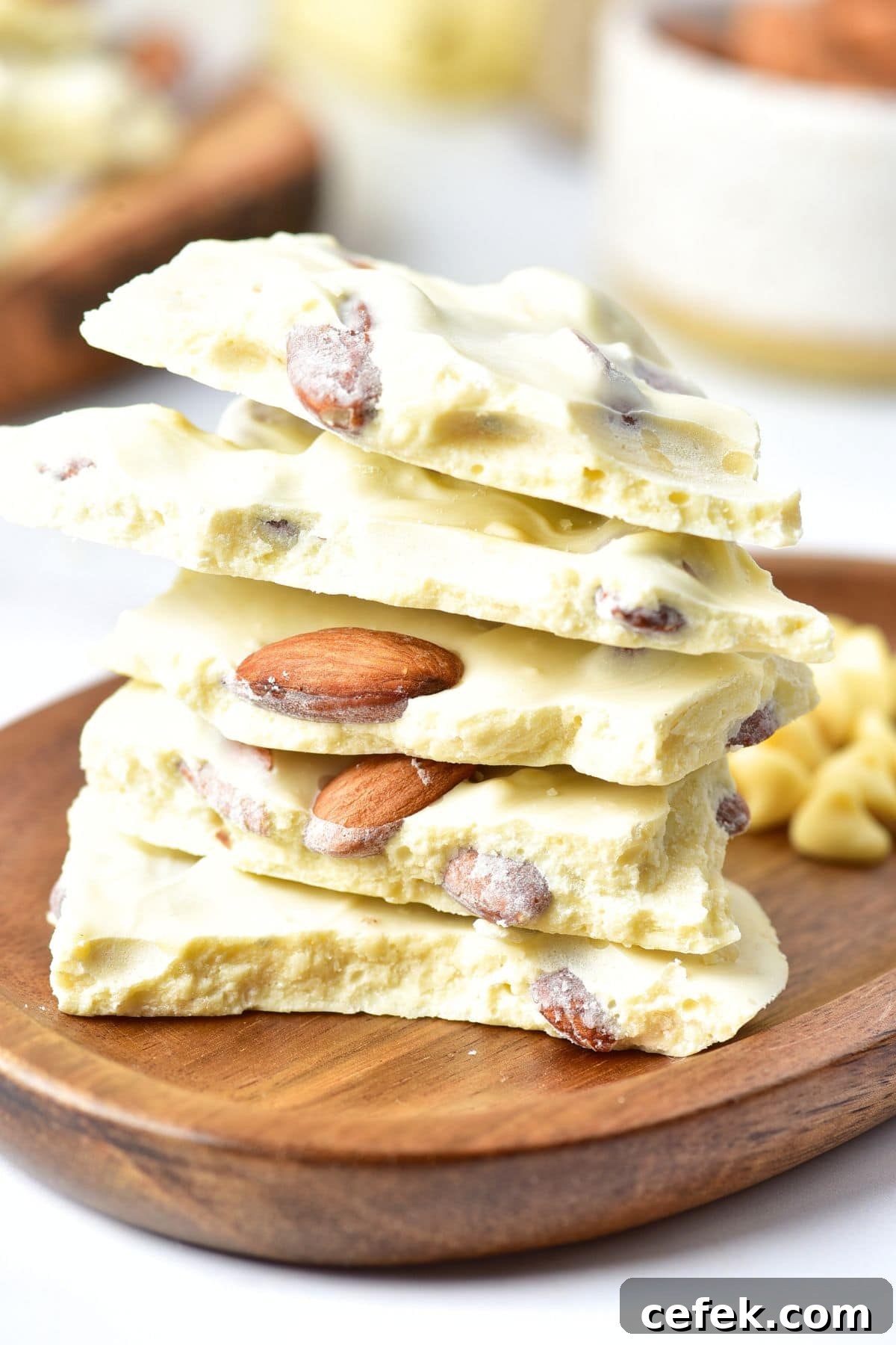 A stack of almond bark made with white chocolate on wooden board