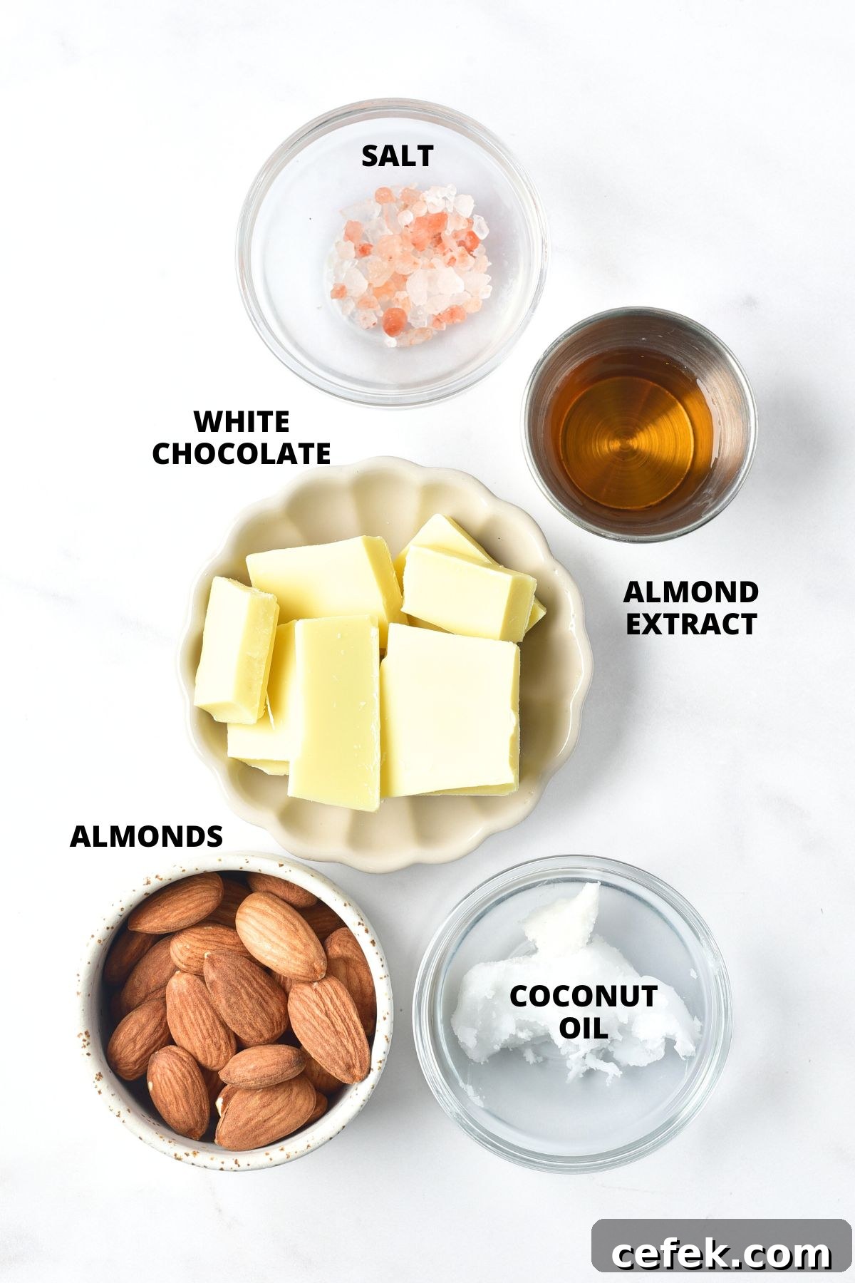 Ingredients for white chocolate almond bark recipe laid out on white marble board.