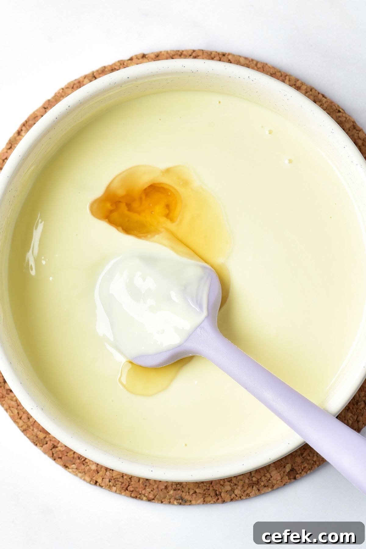 Almond extract in a bowl of melted white chocolate