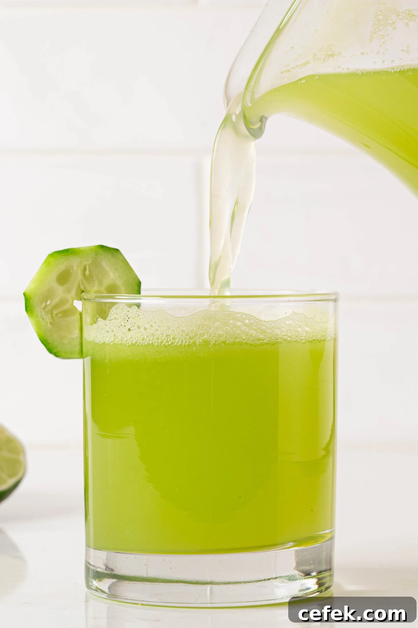 A glass of agua de pepino being poured.