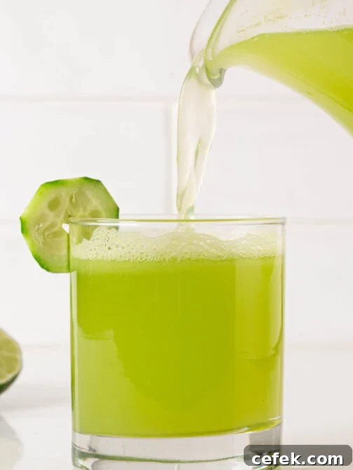 A glass of agua de pepino being poured.
