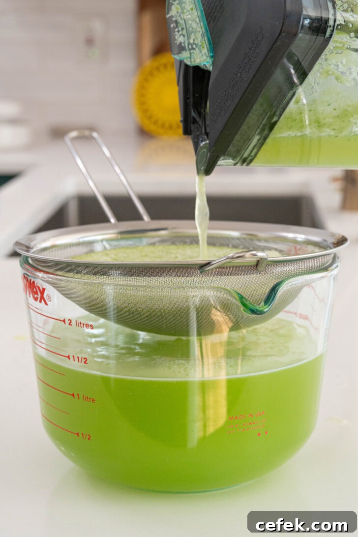 Agua de pepino straining into a pitcher.