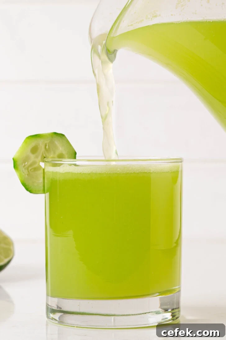 A glass of agua de pepino being poured.