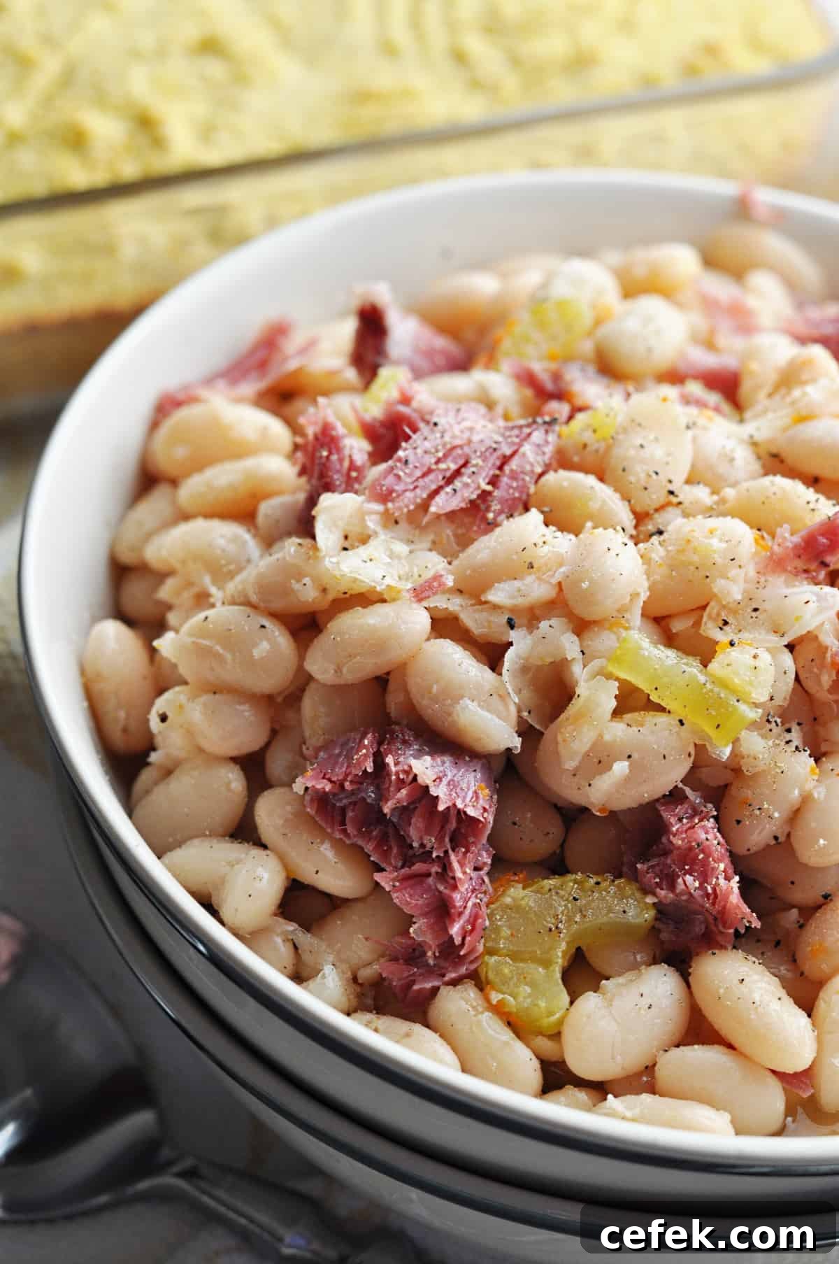 Great northern beans with ham close up in bowl