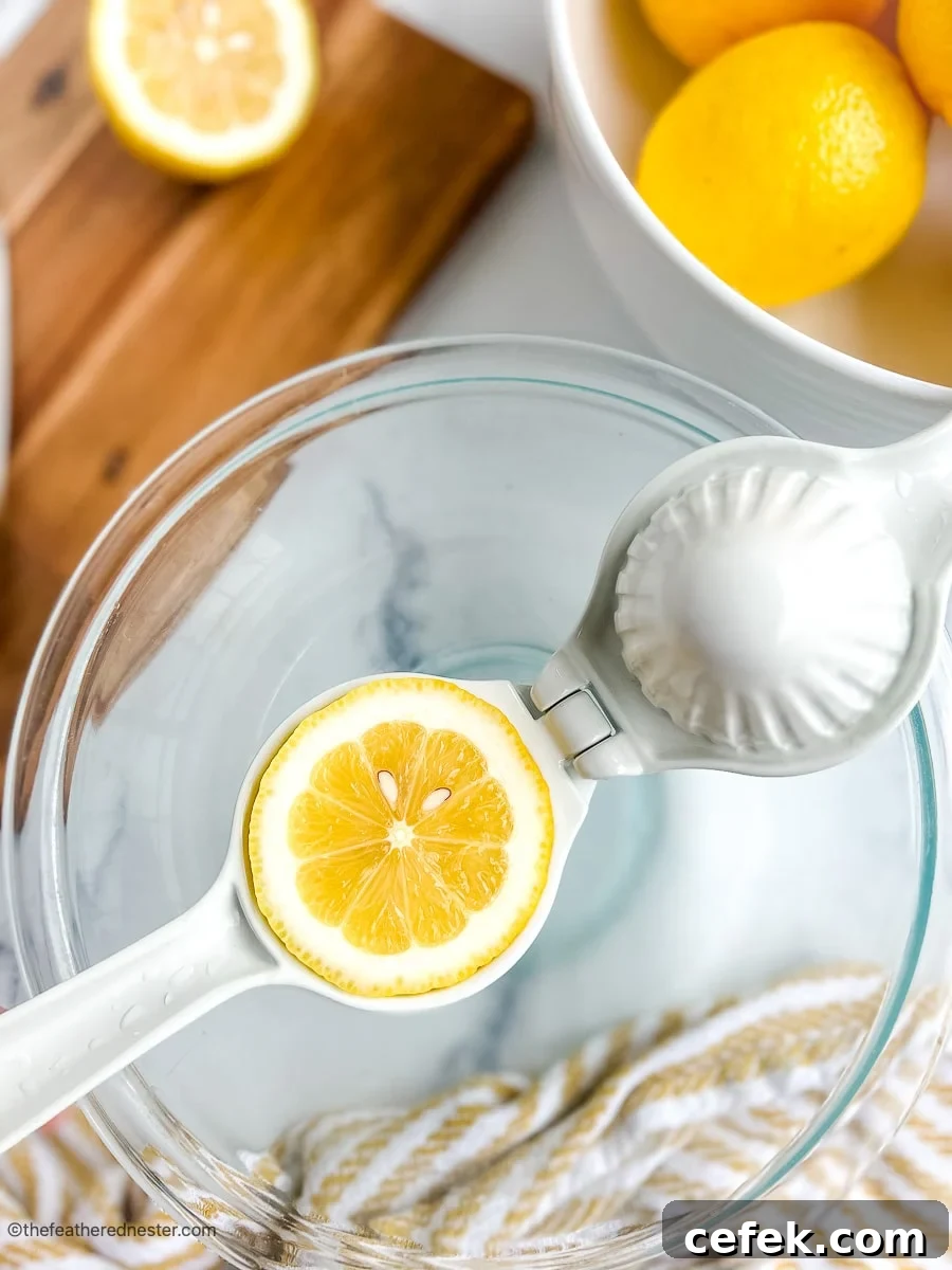 Squeezing fresh lemons in a glass bowl for homemade lemonade.
