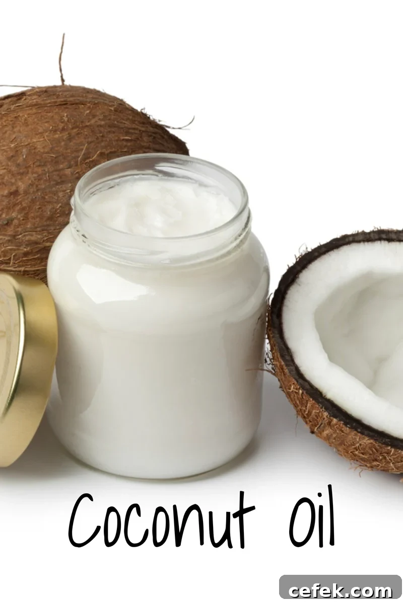 jar of coconut oil with two coconuts next to it