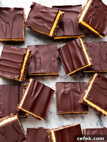 Nanaimo bars cut into squares and served on a marble surface.
