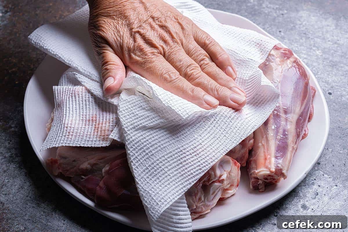 Patting dry lamb shanks on a plate