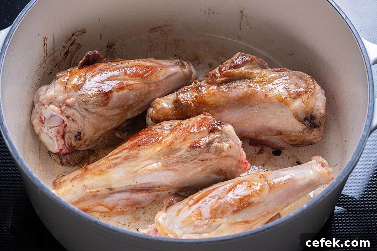 lamb shanks seared in a blue pot
