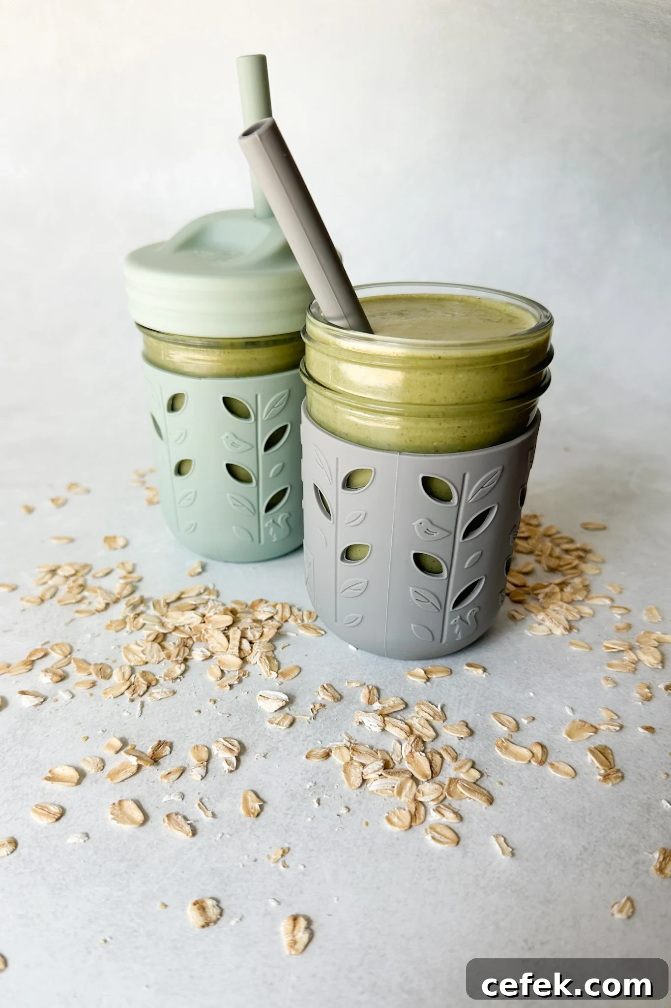 Spinach banana smoothies in toddler glass tumblers with silicone sleeves.