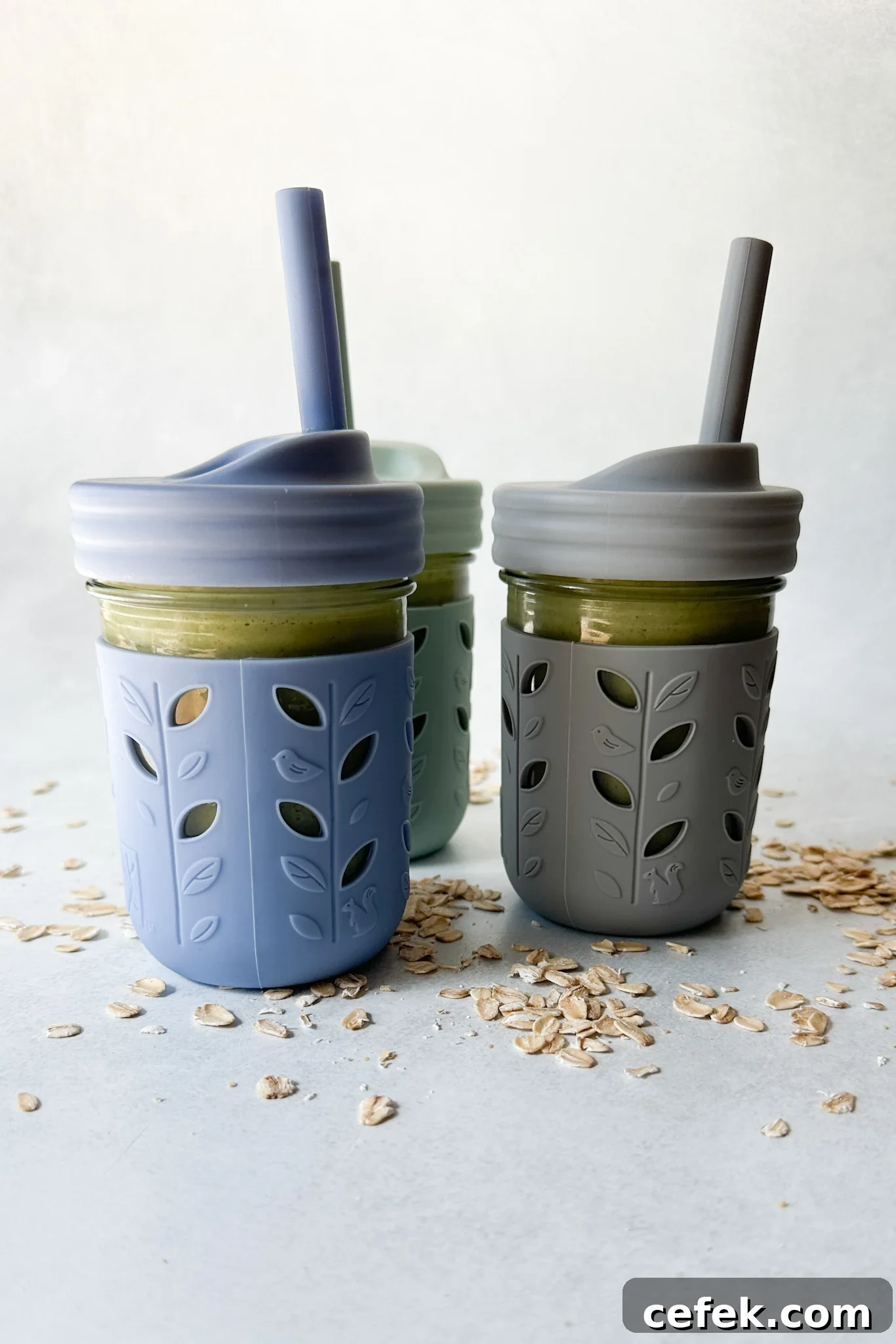 Spinach banana smoothies in toddler glass tumblers with silicone sleeves.