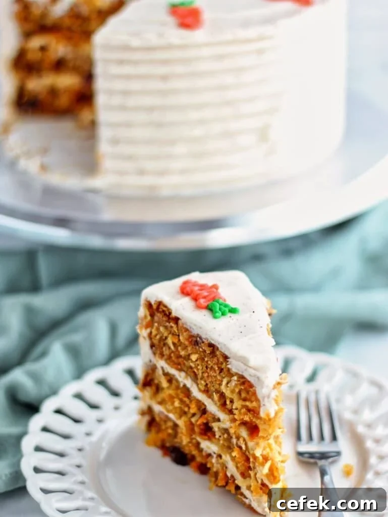 slice of gluten free carrot cake on white plate with whole cake on cake stand in the background.