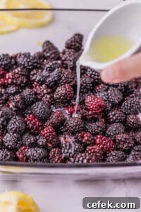 pouring lemon juice over fresh blackberries.