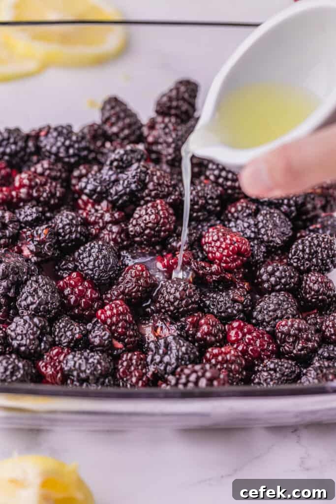 pouring lemon juice over fresh blackberries.
