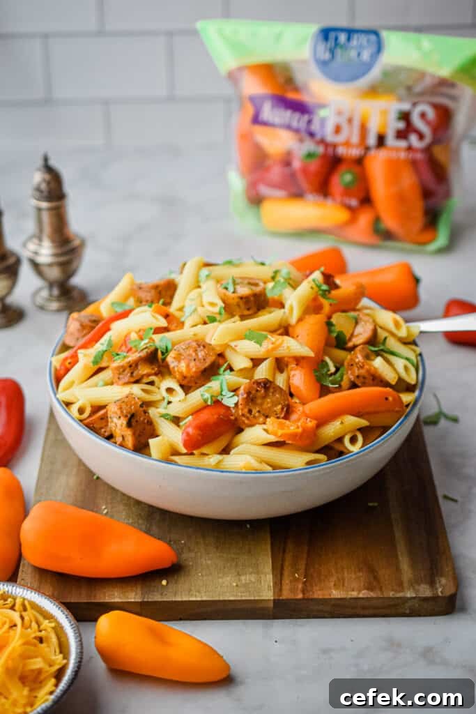 The bowl of pasta is on a wooden cutting board surrounded by peppers