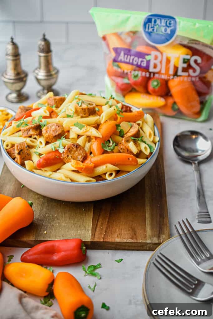 The bowl of pasta is on a wooden cutting board with the bag of peppers in the background.