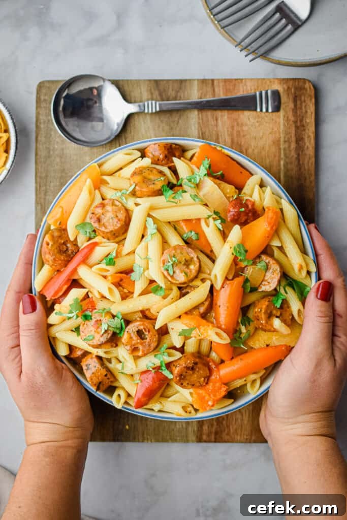 Two hands are holding the bowl of pasta