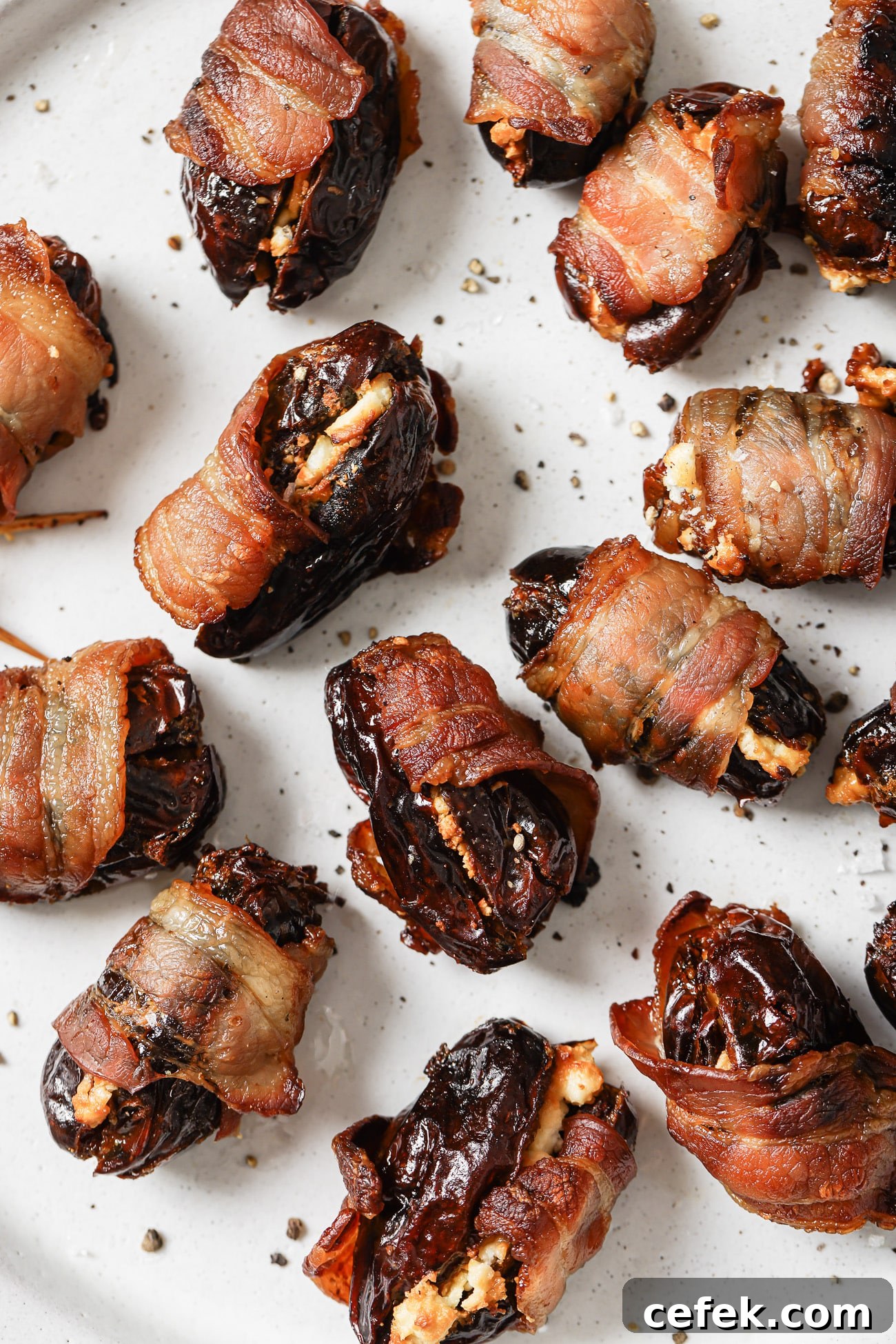Close up of bacon-wrapped dates on a white plate. 