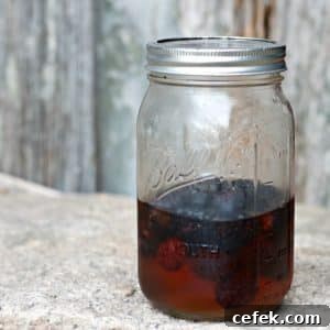 A photo of blackberries in the pickling liquid in a Mason Jar