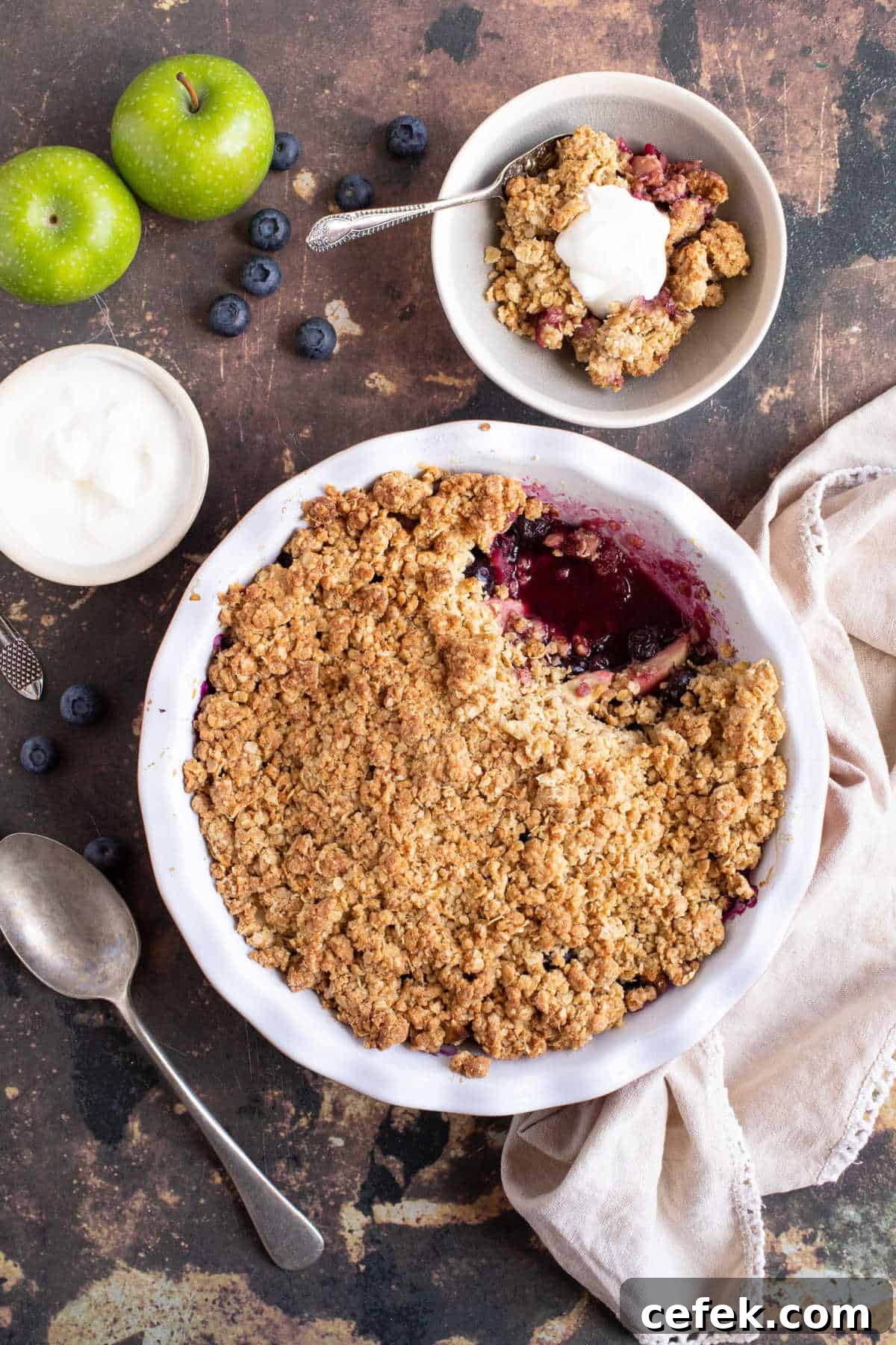 Apple and blueberry crumble in a bowl served with yogurt.