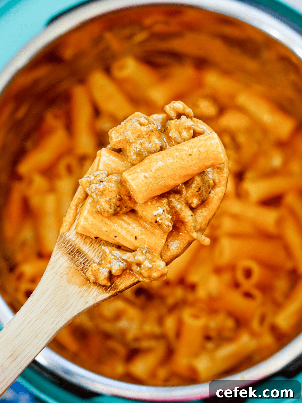 instant pot with pasta and spoon with rigatoni and sausage