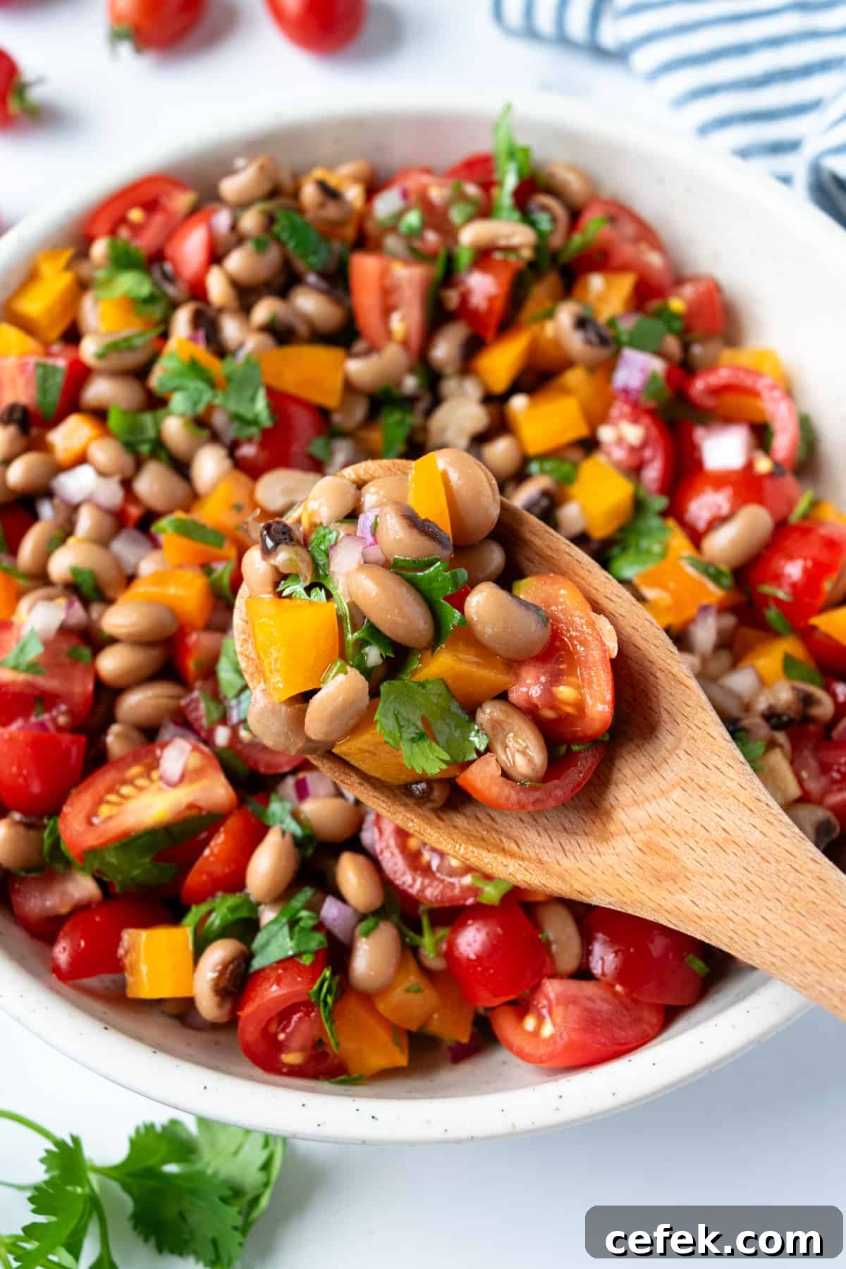 A wooden spoonful of black eyed peas salad.