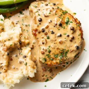 a plate with peppercorn pork chops, green beans, and mashed potatoes