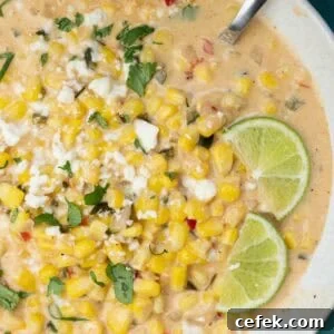 a white bowl filled with Mexican Street Corn Soup, garnished with lime wedges
