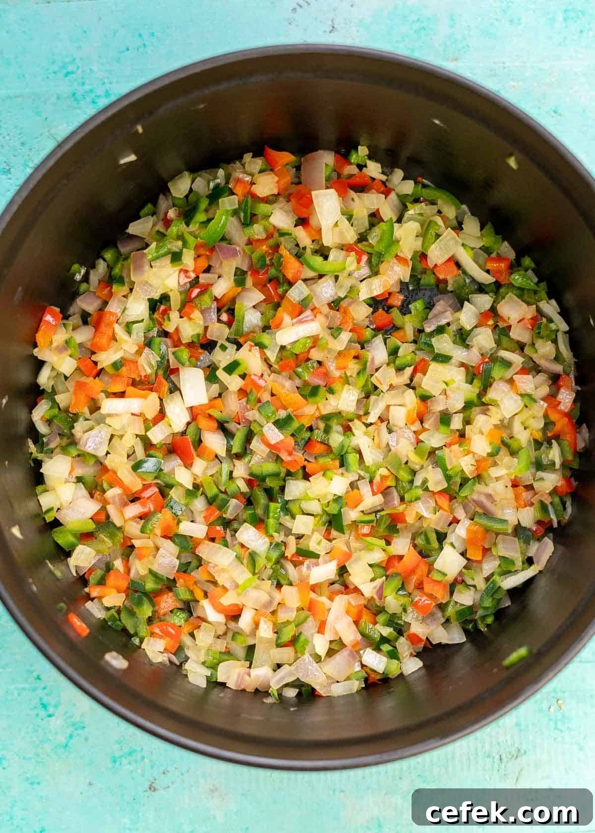 sauteed onions and peppers in a cast iron soup pot
