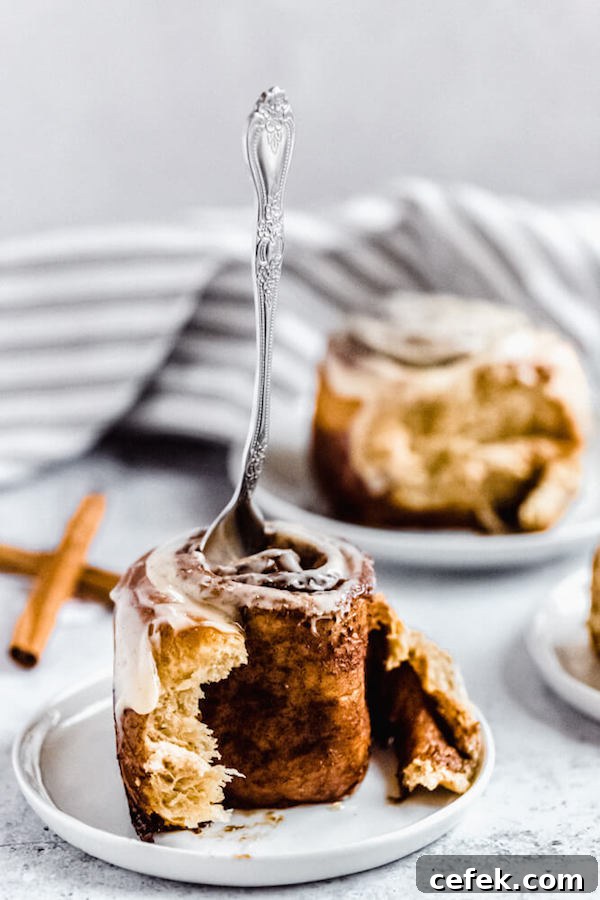 fork stuck into the top of an unraveled cinnamon roll
