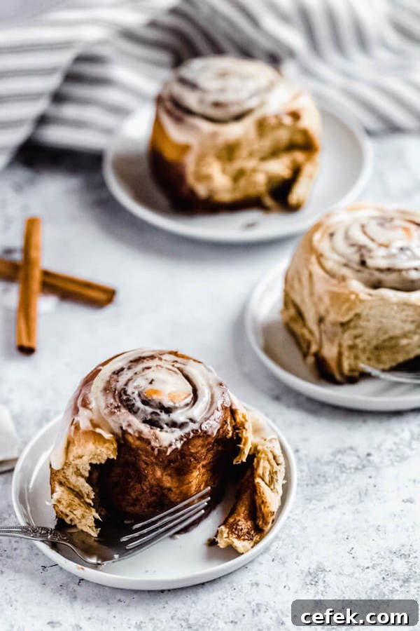 three cinnamon rolls with one half eaten