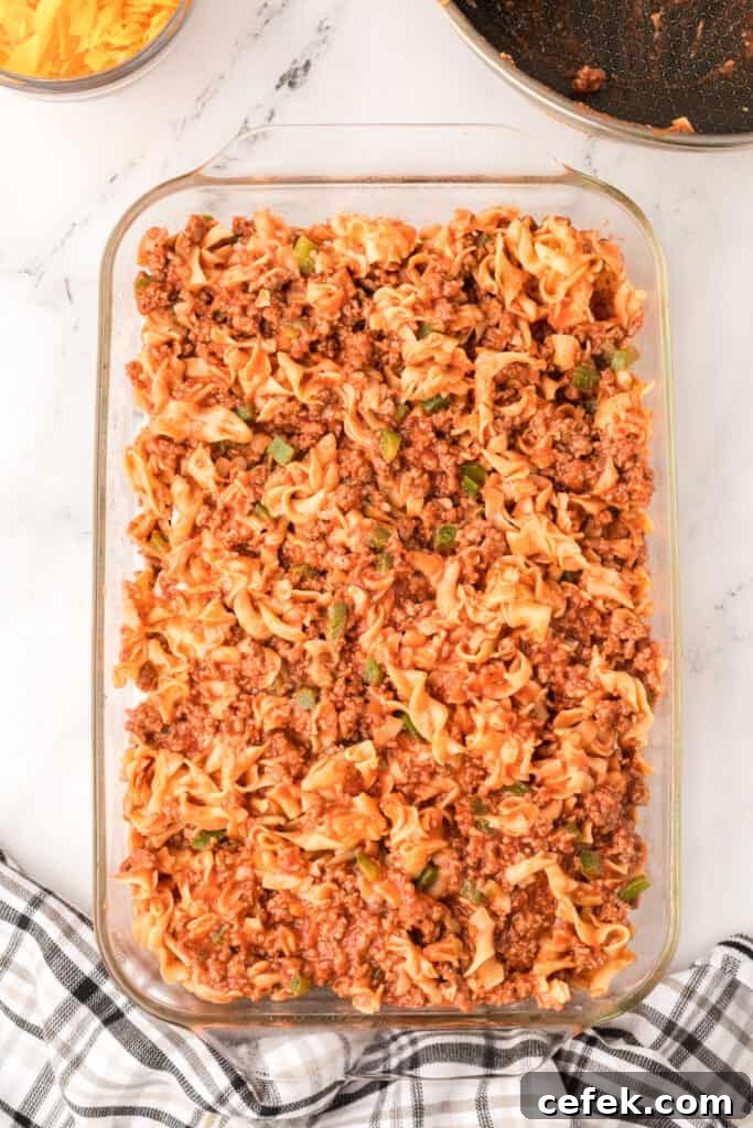 second layer of beef and noodle mixture added on top in baking dish