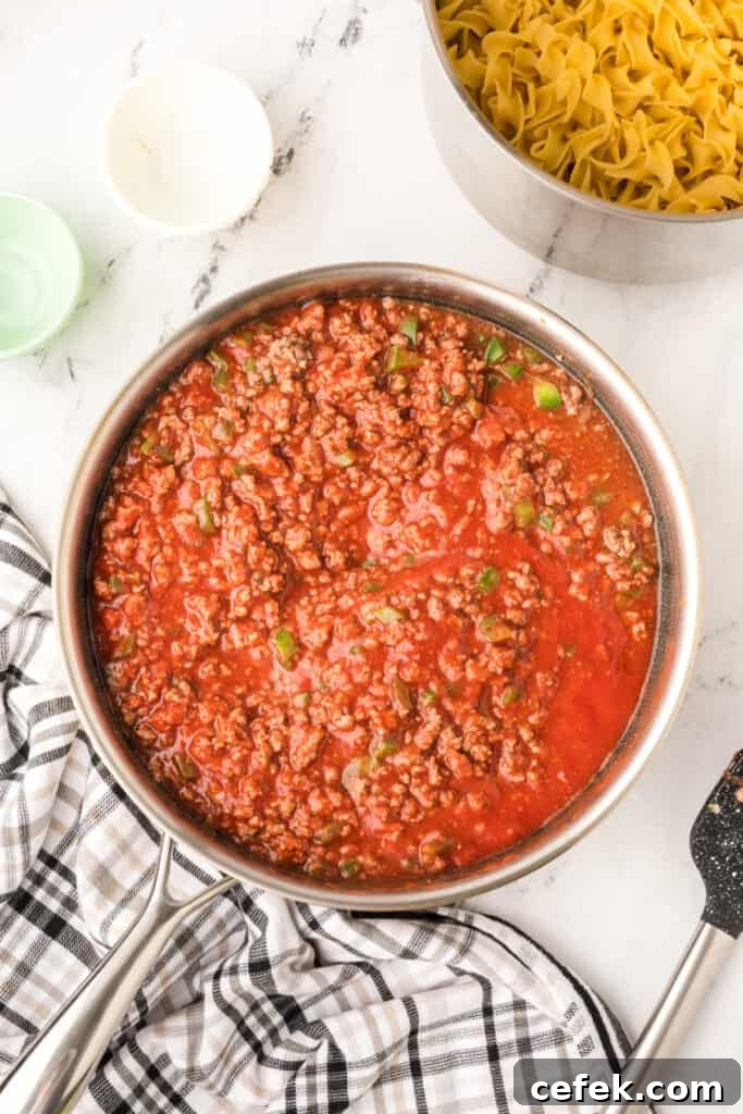 beef and tomato sauce mixture fully combined and simmering in skillet