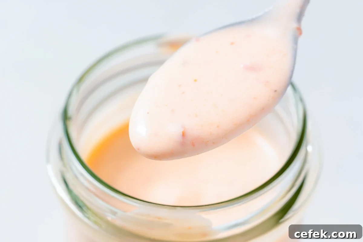 a spoonful of Bang Bang sauce over a jar.