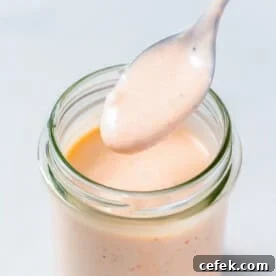 a jar filled with Bang Bang sauce with a spoonful of the sauce.
