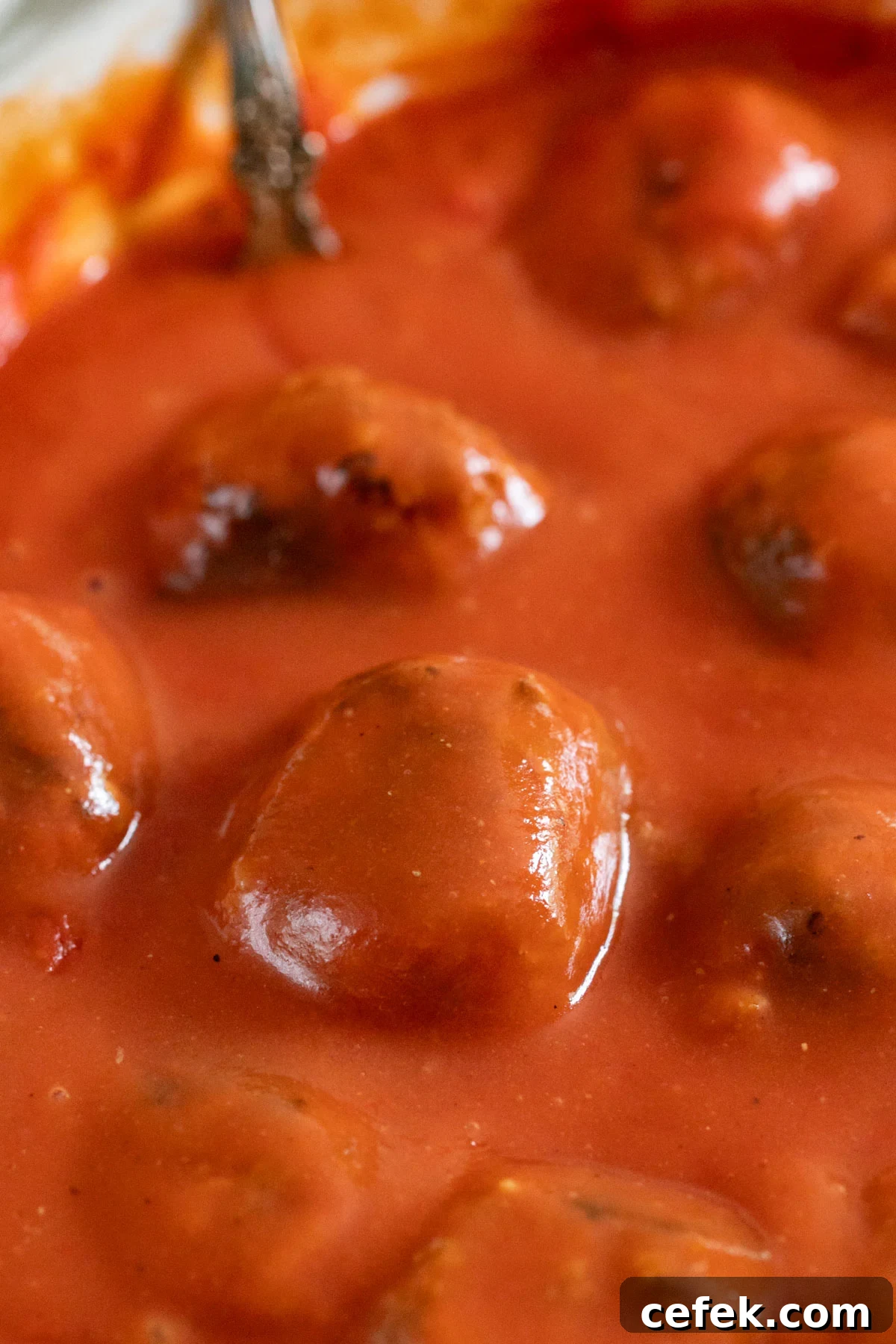 A close up of baked porcupine balls covered in sauce.
