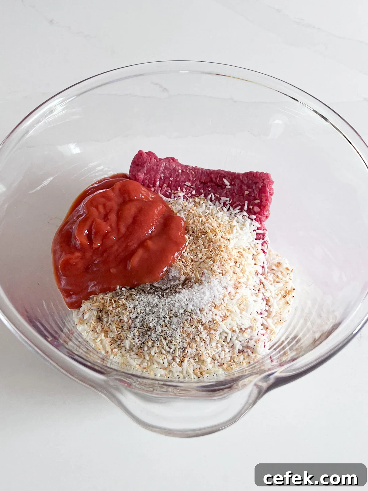 Meatball ingredients in a glass bowl.