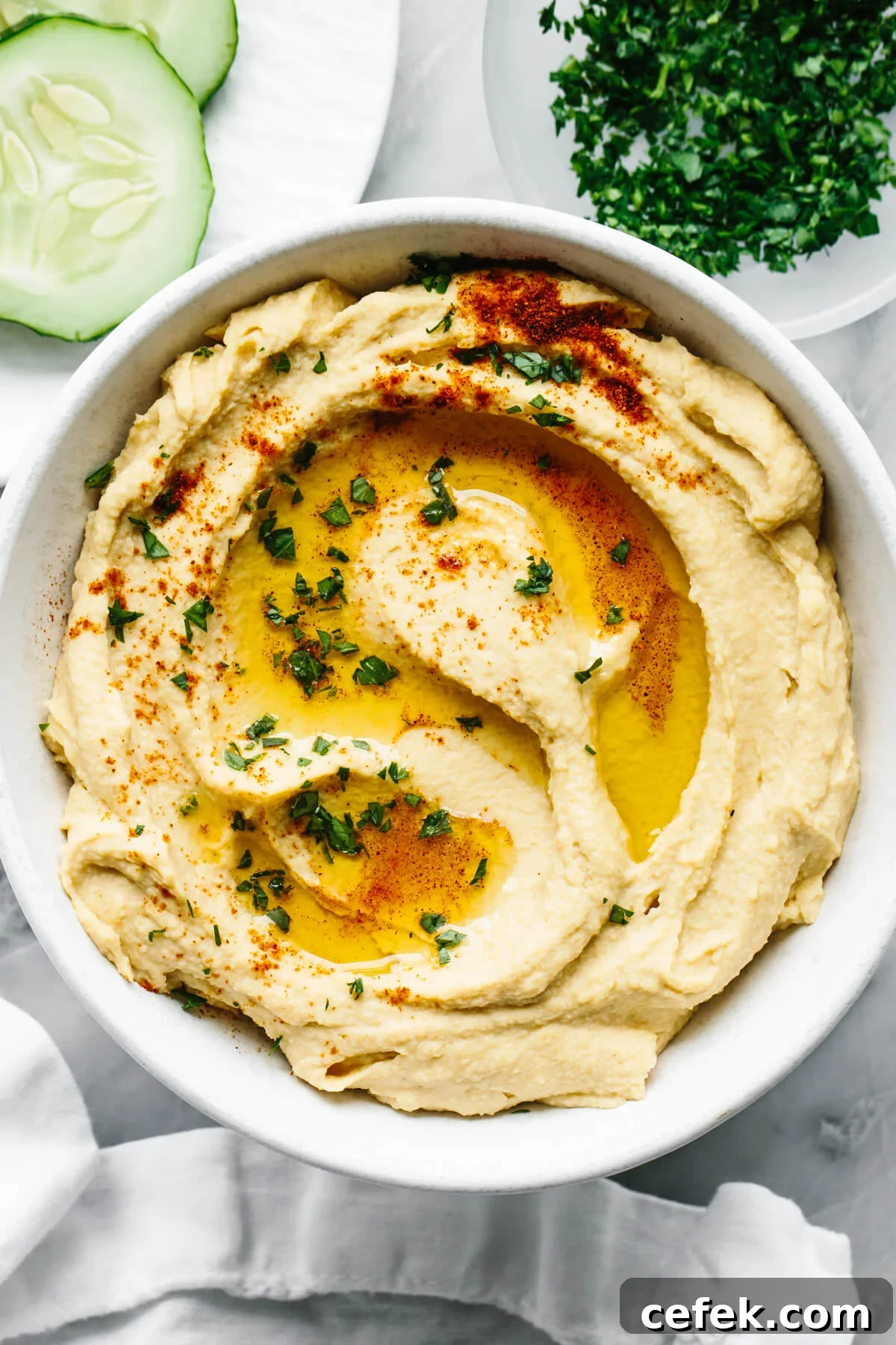 A bowl of homemade hummus next to a napkin