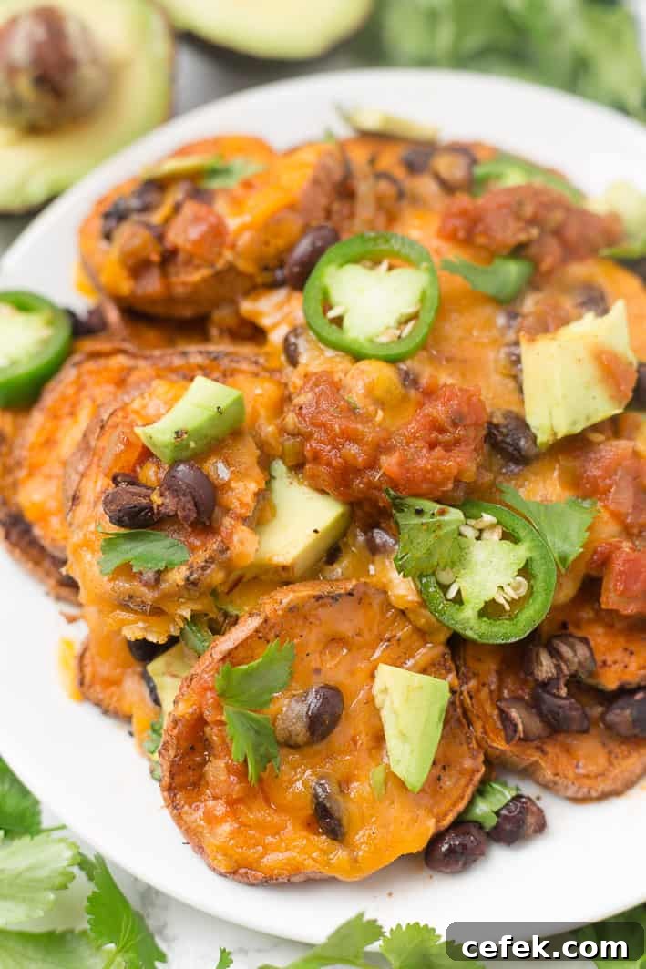 Loaded sweet potato nachos that are even better than traditional nachos! Healthy nachos with sweet potato, avocado, black beans, and melty cheese- what's not to love?!