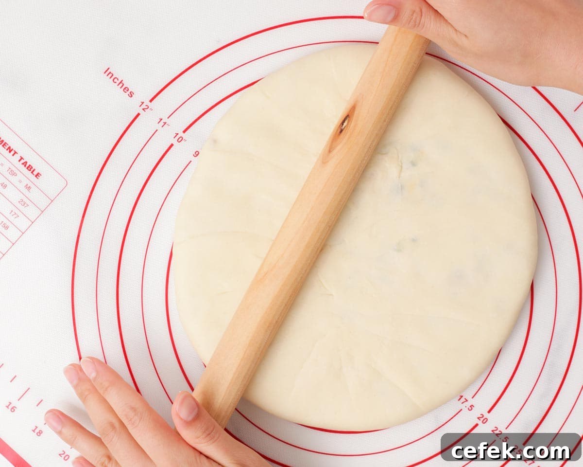 Rolling out the dough filled with the loaded potato filling.