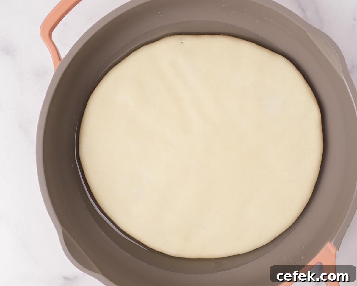 Placing the dough in the hot pan with oil.