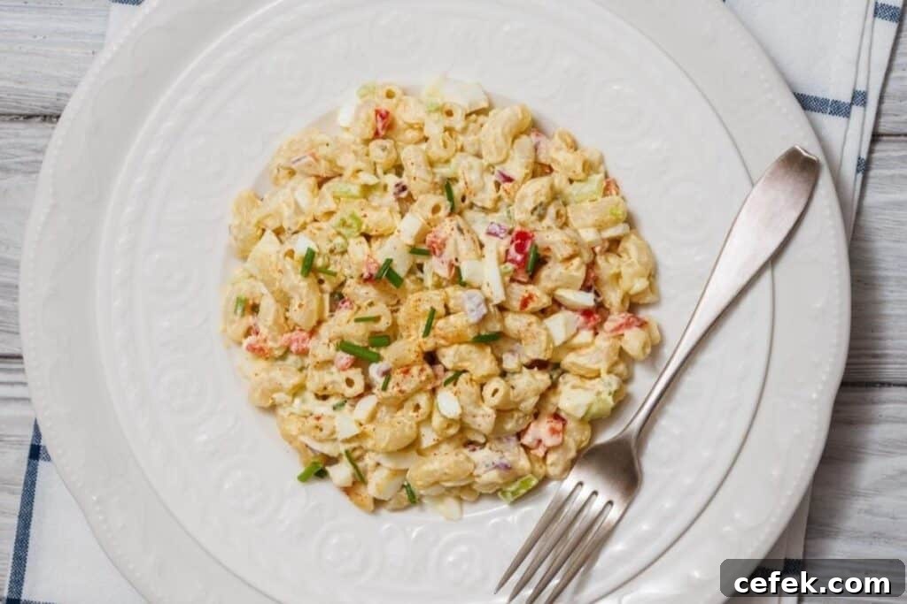 A plate of Deviled Egg Pasta Salad served with a fork on a white plate.