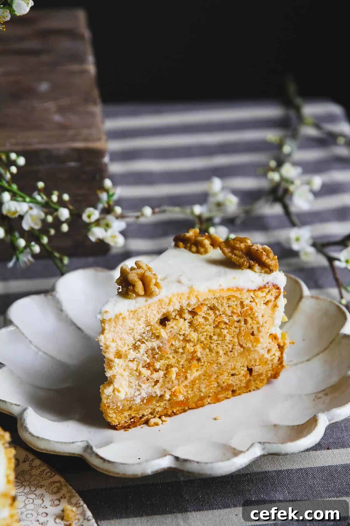 A close up of a carrot cake cheesecake slice on a white plate.