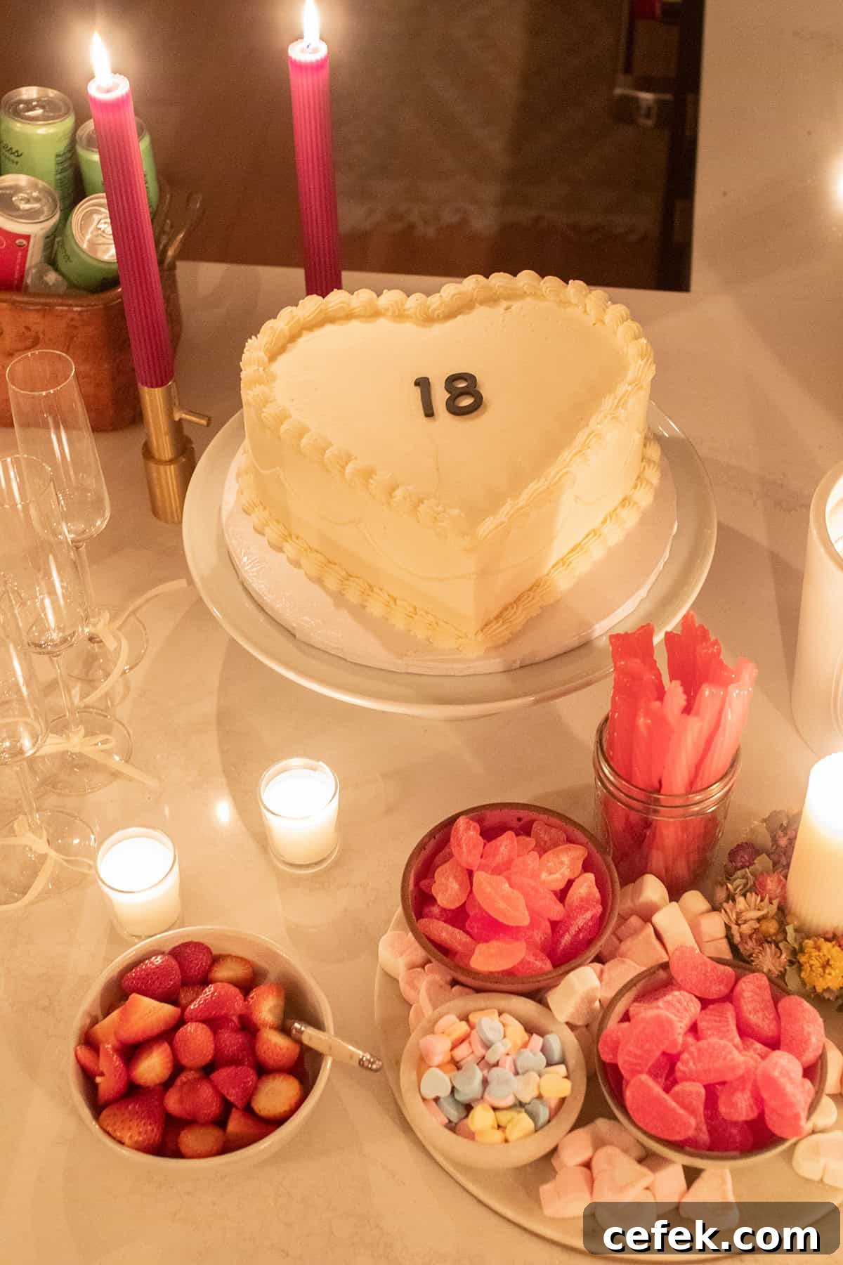 Heart shaped cake with candles and candy for a birthday party.