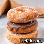 Gluten Free Donuts (Fried, Bakery Style) stacked on top of each other with chocolate frosting and sugared outsides