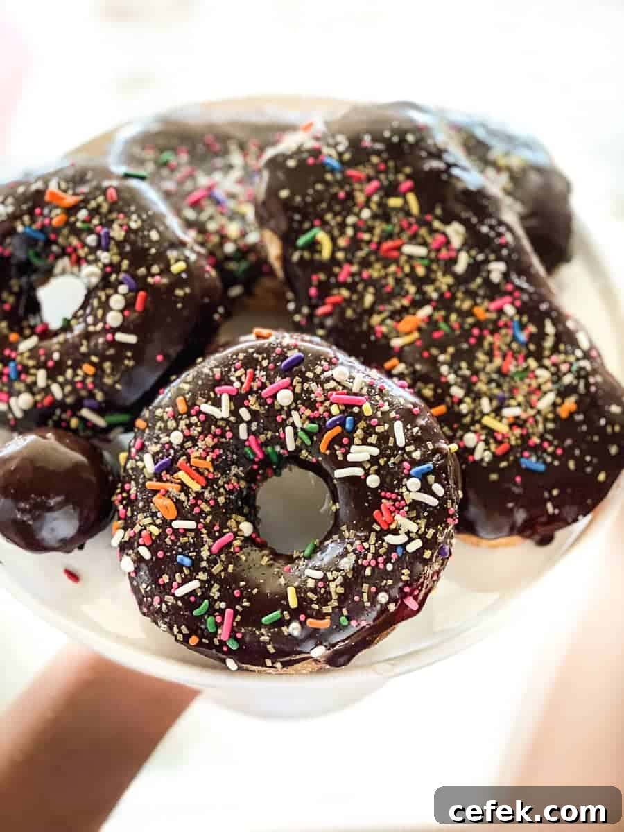 Chocolate glazed sprinkled gluten-free donuts on a cake stand