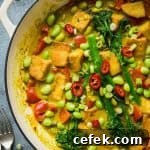 Close up of a cast iron pan of easy vegan lemongrass coconut curry with broccoli, tofu and edamame.